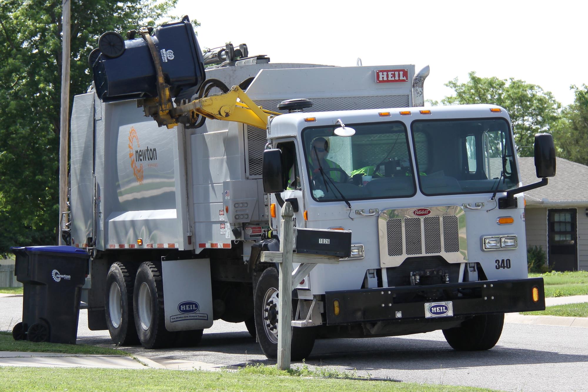 Automated trash truck dumping a trash cart
